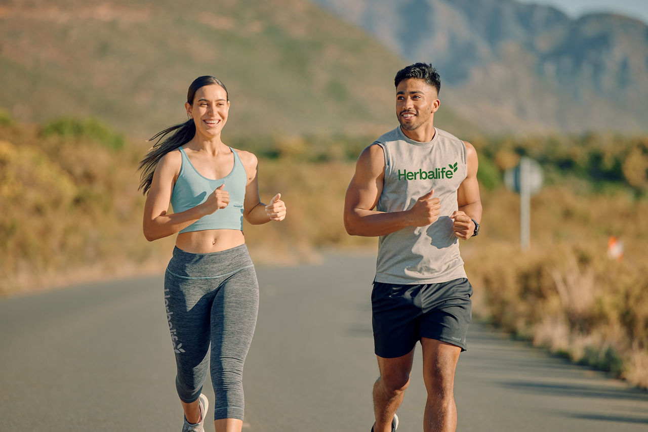 Friends running on a road in the mountains