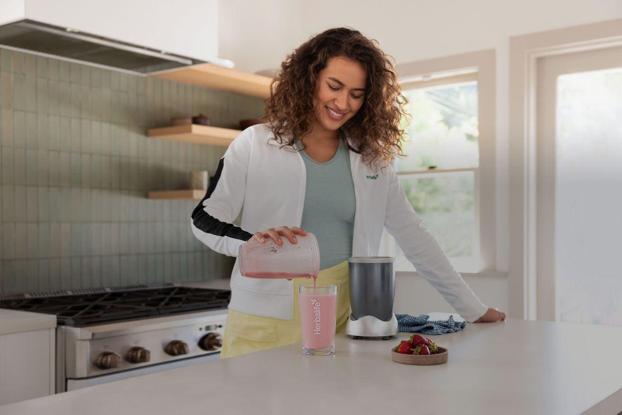 woman kitchen drinking formula 1 shake